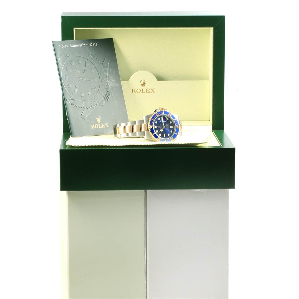 The Rolex Submariner 116613 Men's Steel and Gold (two tone) Blue Dial 116613 Men's Steel and Gold (two tone) Blue Dial watch is displayed in its box alongside the manual, viewed from the front.