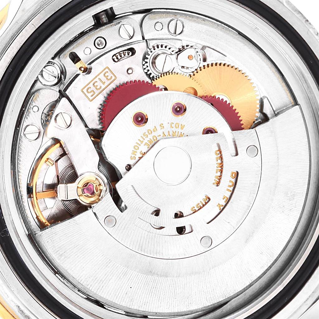 This image shows a close-up of the internal mechanism of a Rolex Submariner 16613 Men's Steel and Gold (two tone) Blue Dial 16613 Men's Steel and Gold (two tone) Blue Dial watch, specifically the movement and gears.