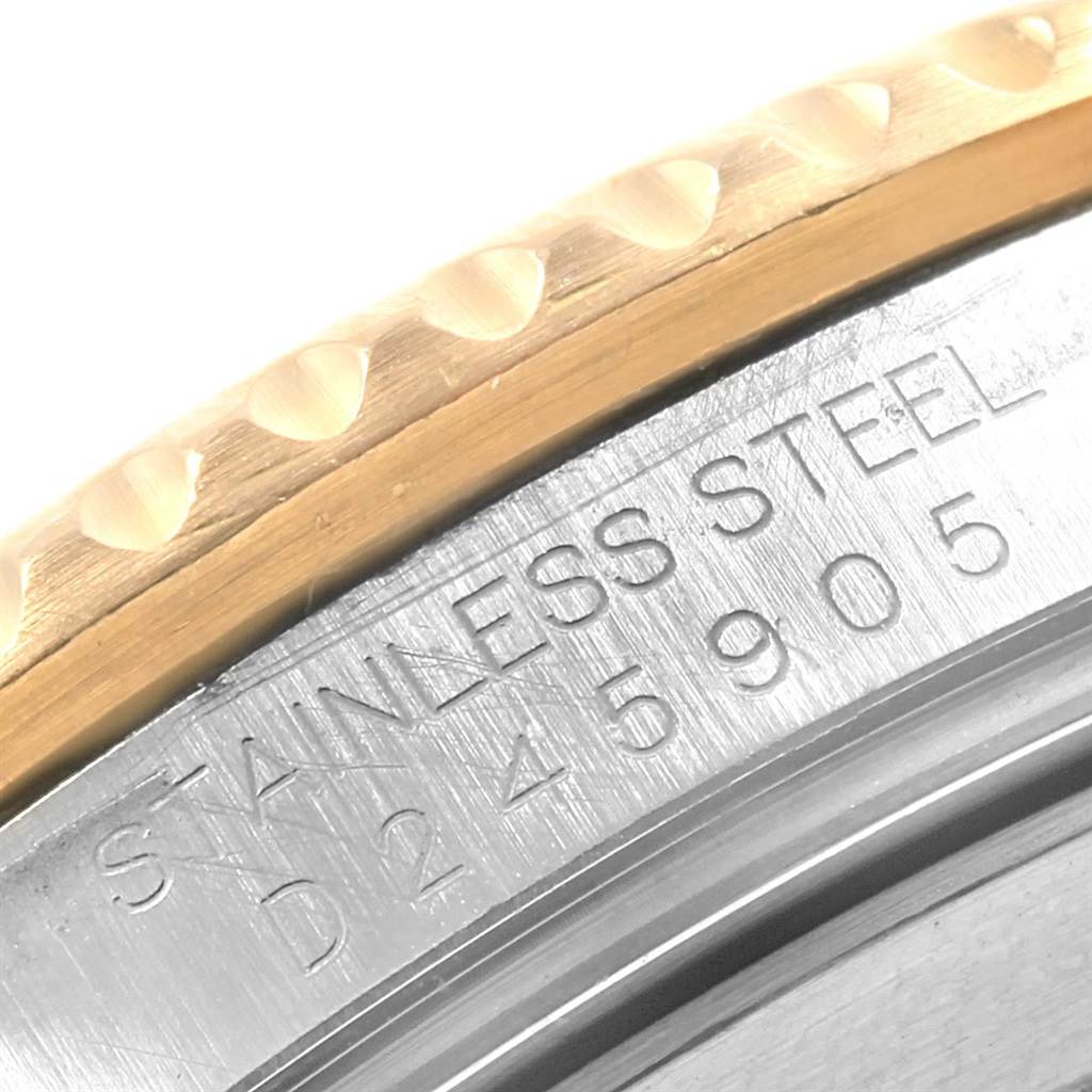 The image shows a close-up of the Rolex Submariner 16613 Men's Steel and Gold (two tone) Blue Dial 16613 Men's Steel and Gold (two tone) Blue Dial model's stainless steel case back edge and part of the bezel.