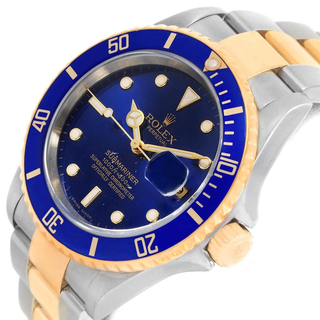 The image shows a close-up, angled view of a Rolex Submariner 16613 Men's Steel and Gold (two tone) Blue Dial 16613 Men's Steel and Gold (two tone) Blue Dial, highlighting its blue dial and bezel, gold accents, and part of the bracelet.