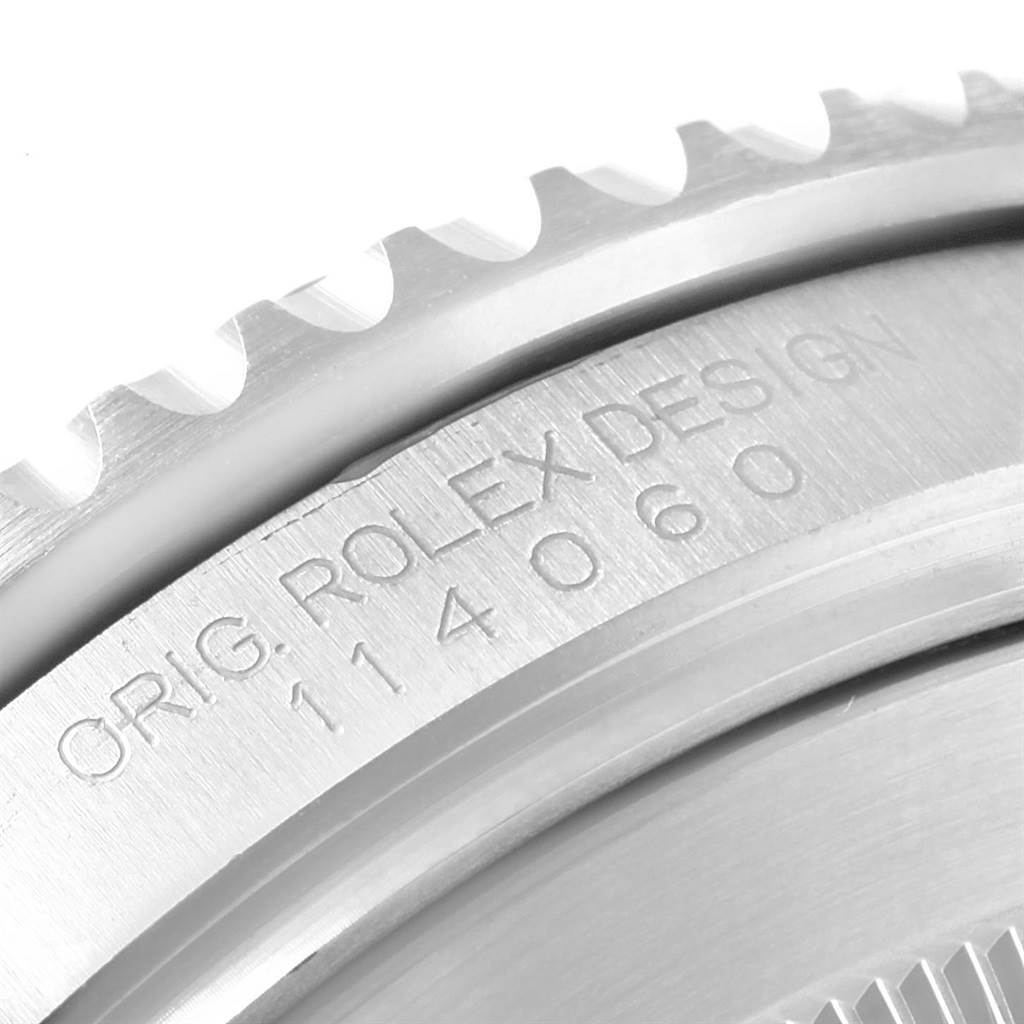 This image shows a close-up of the bezel and engraved serial number on a Rolex Submariner 114060 Men's Stainless Steel Black Dial 114060 Men's Stainless Steel Black Dial watch.