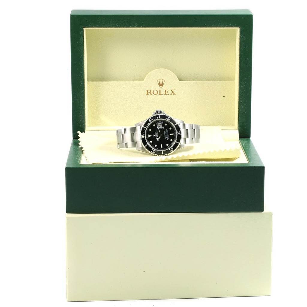 The image shows a Rolex Submariner 16610 Men's Stainless Steel Black Dial 16610 Men's Stainless Steel Black Dial displayed inside an open green and cream-colored Rolex box.