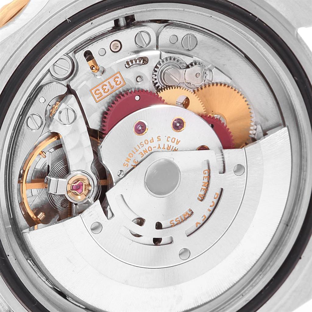 The image shows an up-close view of the Rolex Submariner 16613 Men's Steel and Gold (two tone) Grey Dial 16613 Men's Steel and Gold (two tone) Grey Dial's intricate internal movement and gears.