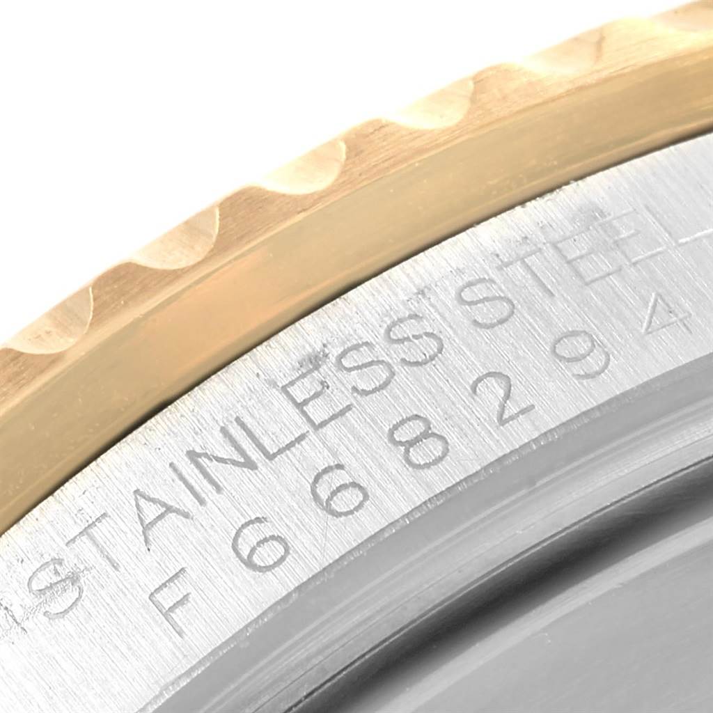 The image shows a close-up of the edge and stainless steel case with visible serial number of a Rolex Submariner 16613 Men's Steel and Gold (two tone) Grey Dial 16613 Men's Steel and Gold (two tone) Grey Dial watch.