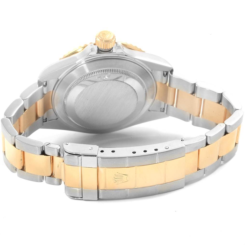 The image shows the back view of a Rolex Submariner 16613 Men's Steel and Gold (two tone) Grey Dial 16613 Men's Steel and Gold (two tone) Grey Dial, highlighting its two-tone strap, clasp, and case back.