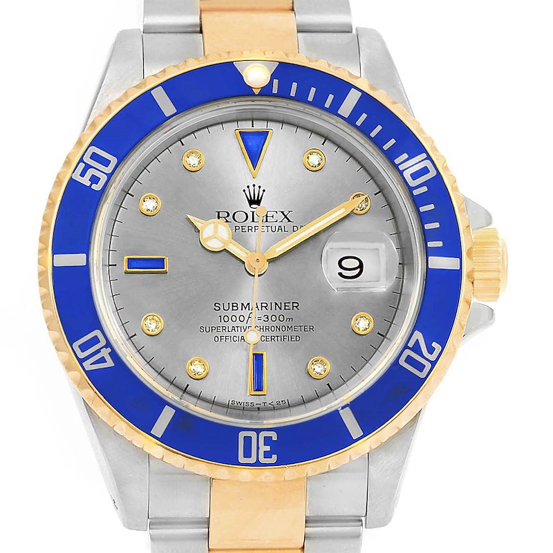 The image shows a front view of a Rolex Submariner 16613 Men's Steel and Gold (two tone) Grey Dial 16613 Men's Steel and Gold (two tone) Grey Dial with a blue and gold bezel, silver dial, date window, and two-tone bracelet.