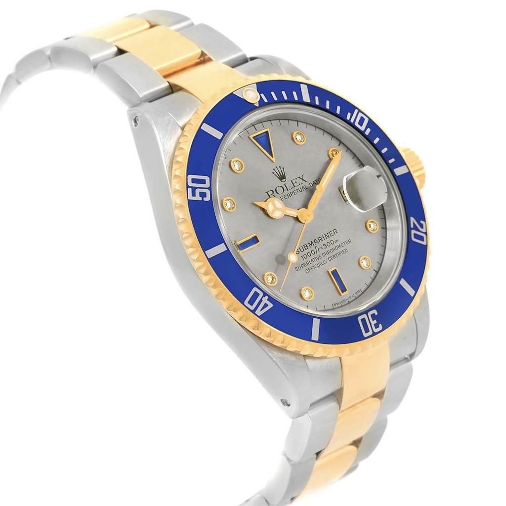 The image shows a Rolex Submariner 16613 Men's Steel and Gold (two tone) Grey Dial 16613 Men's Steel and Gold (two tone) Grey Dial watch at a three-quarter angle, highlighting its two-tone bracelet, blue bezel, and grey dial.