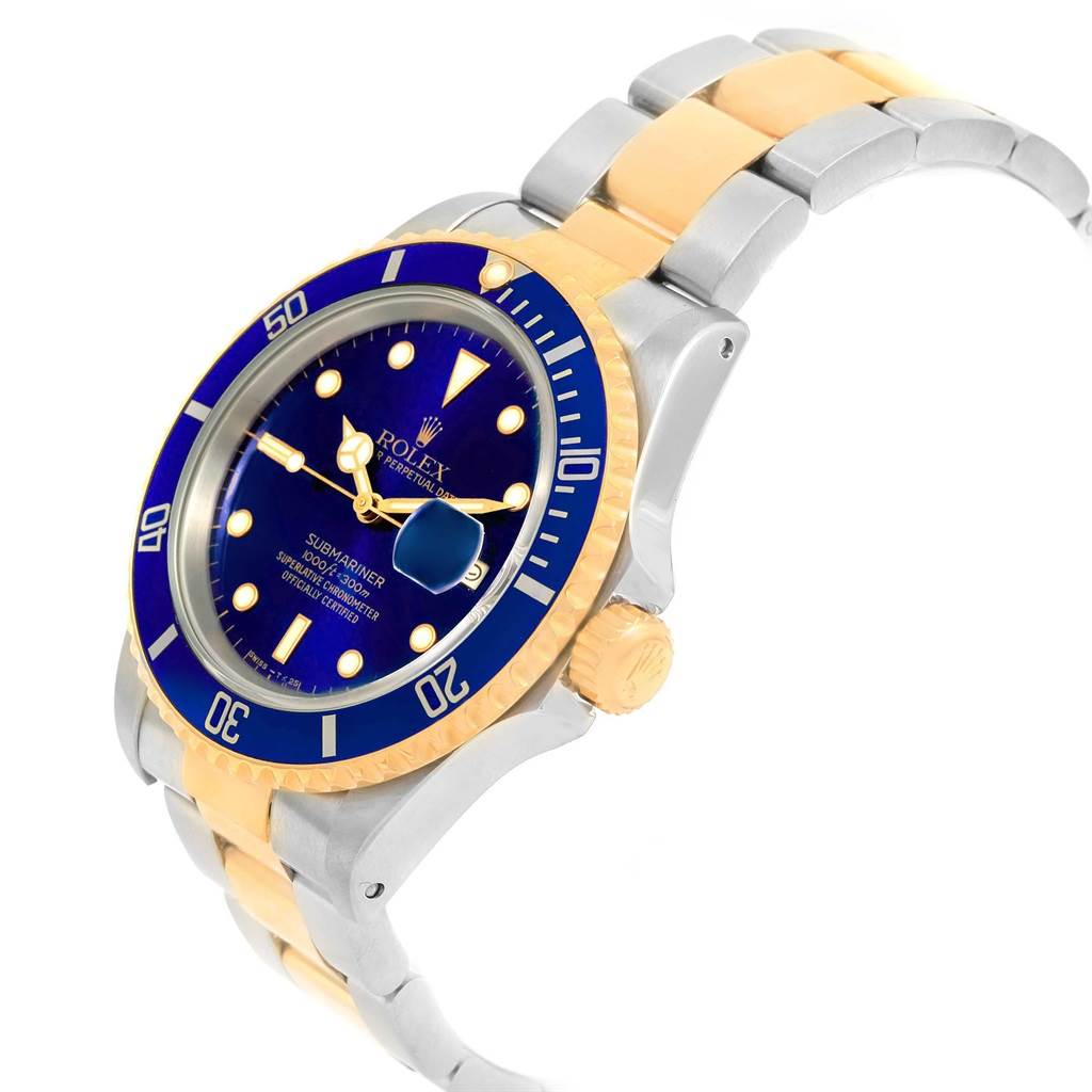 The image shows a Rolex Submariner 16613 Men's Steel and Gold (two tone) Blue Dial 16613 Men's Steel and Gold (two tone) Blue Dial watch, captured at a tilted angle, highlighting its blue dial, bezel, and two-tone bracelet.