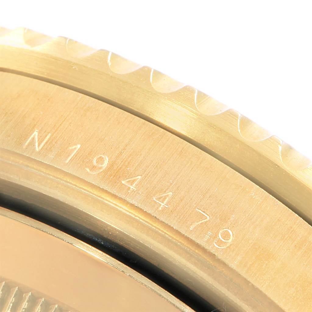 The image shows a close-up of the bezel and case side of a Rolex Submariner 16618 Men's Yellow Gold Purple Dial 16618 Men's Yellow Gold Purple Dial, highlighting the engraved serial number.