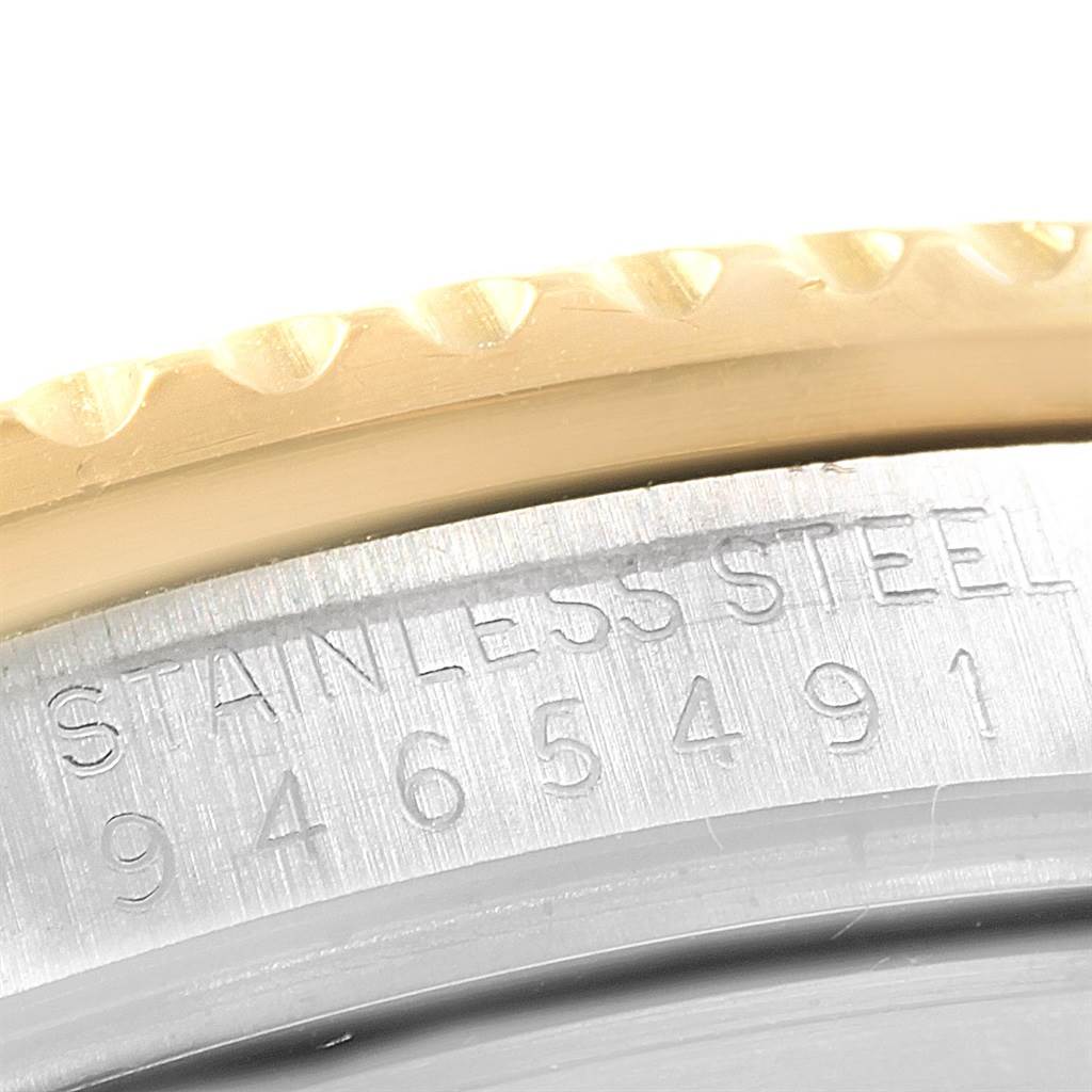 The image shows a close-up of the case and bezel of a Rolex Submariner 16803 Men's Steel and Gold (two tone) Blue Dial 16803 Men's Steel and Gold (two tone) Blue Dial, highlighting the serial number and "STAINLESS STEEL" engraving.