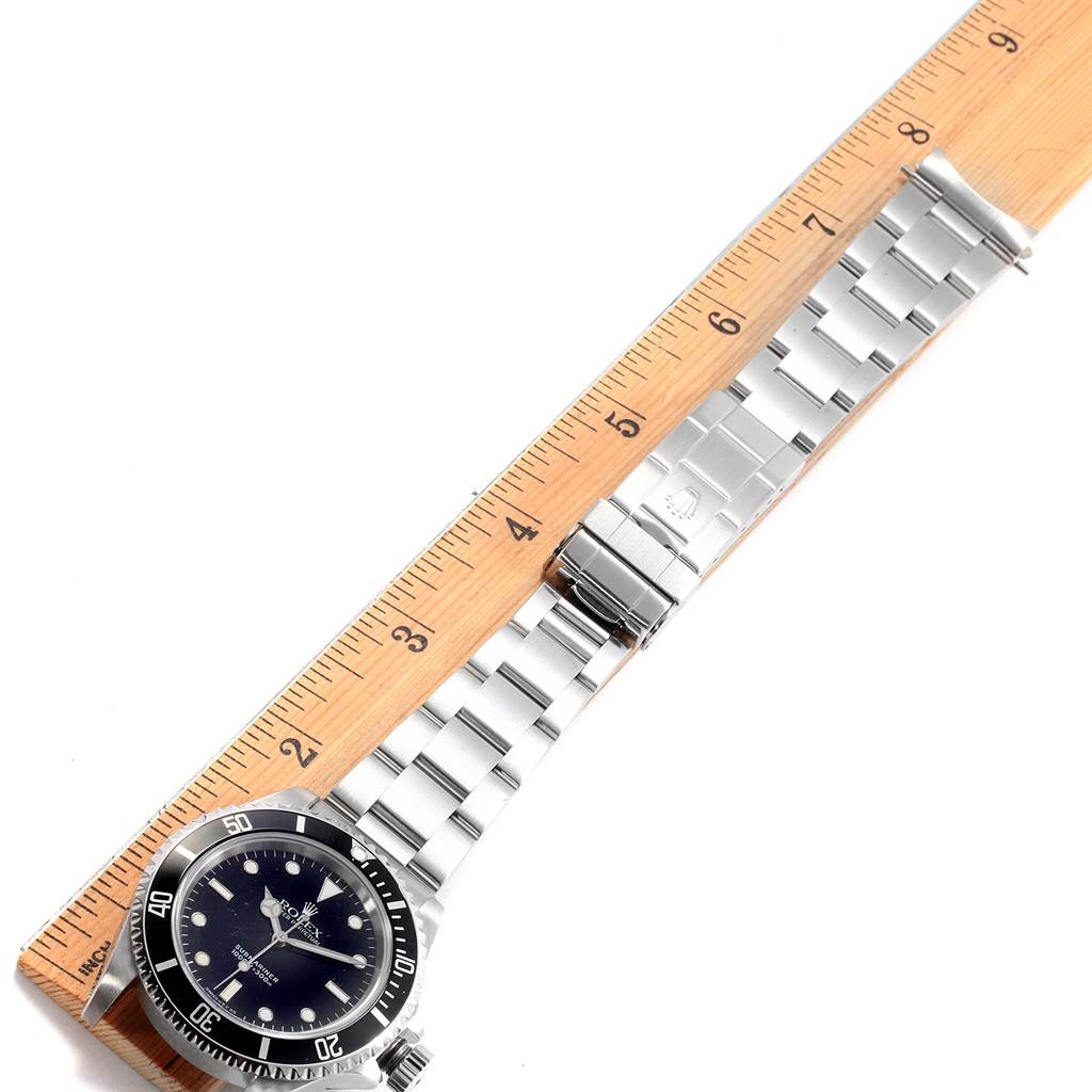 The image shows a Rolex Submariner 14060 Men's Stainless Steel Black Dial 14060 Men's Stainless Steel Black Dial watch laid flat next to a ruler, displaying the watch face and bracelet.