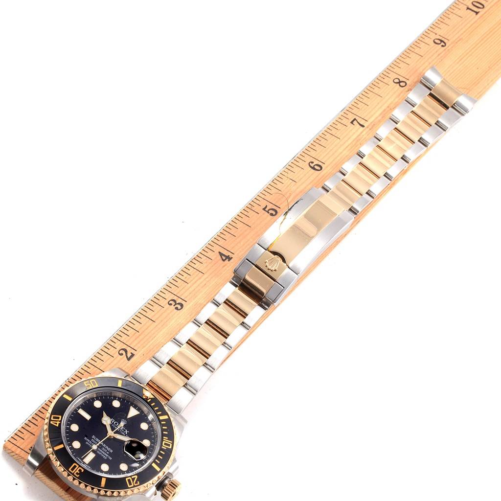 The image shows a Rolex Submariner 116613 Men's Steel and Gold (two tone) Black Dial 116613 Men's Steel and Gold (two tone) Black Dial watch with a two-tone bracelet and clasp, measured alongside a ruler for size reference.