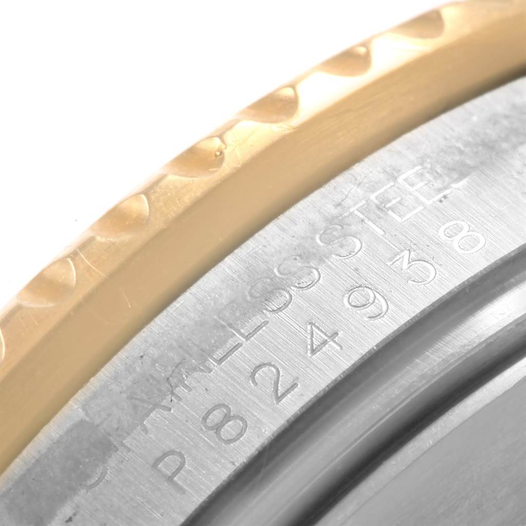 This image shows a close-up of the engraved serial number and part of the bezel on a Rolex Submariner 16613 Men's Steel and Gold (two tone) Blue Dial 16613 Men's Steel and Gold (two tone) Blue Dial watch.