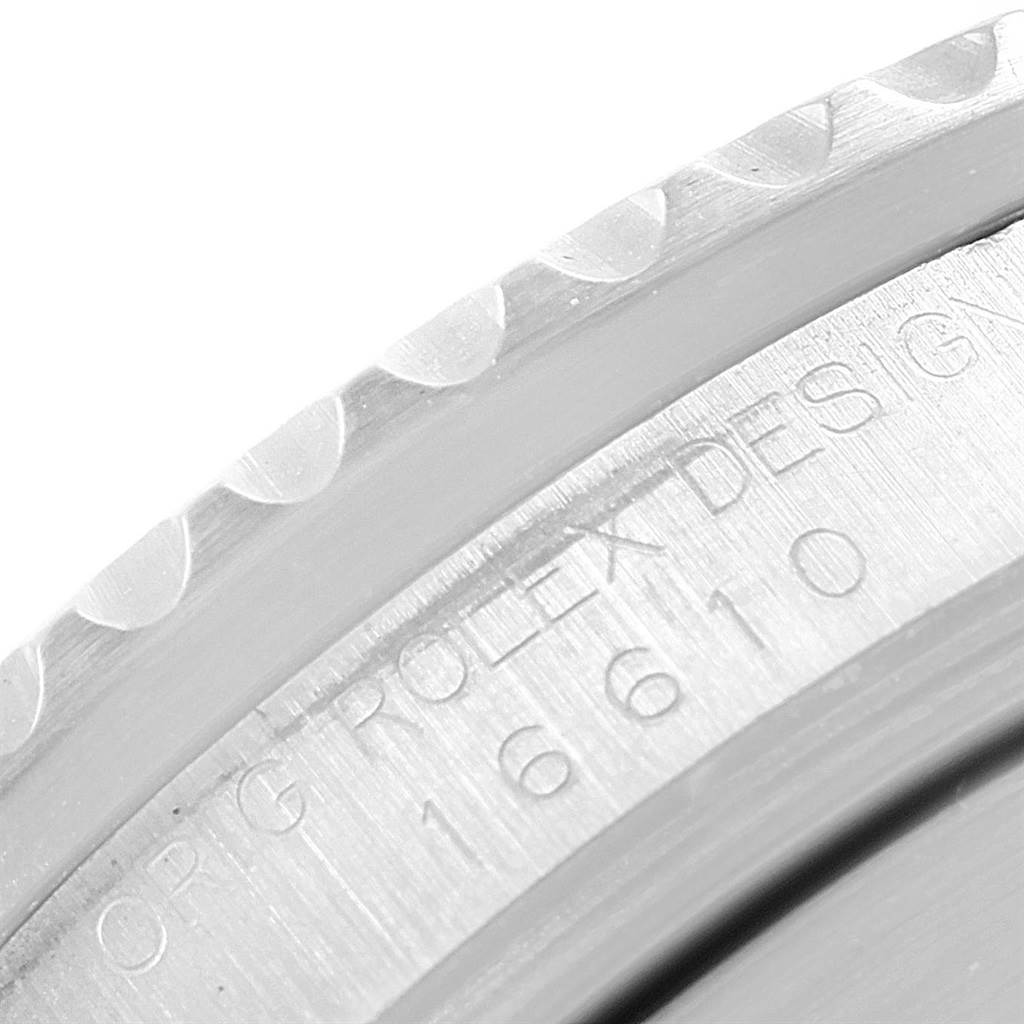 This image shows a close-up angle of the engraved model number and textured bezel of a Rolex Submariner 16610 Men's Stainless Steel Black Dial 16610 Men's Stainless Steel Black Dial.