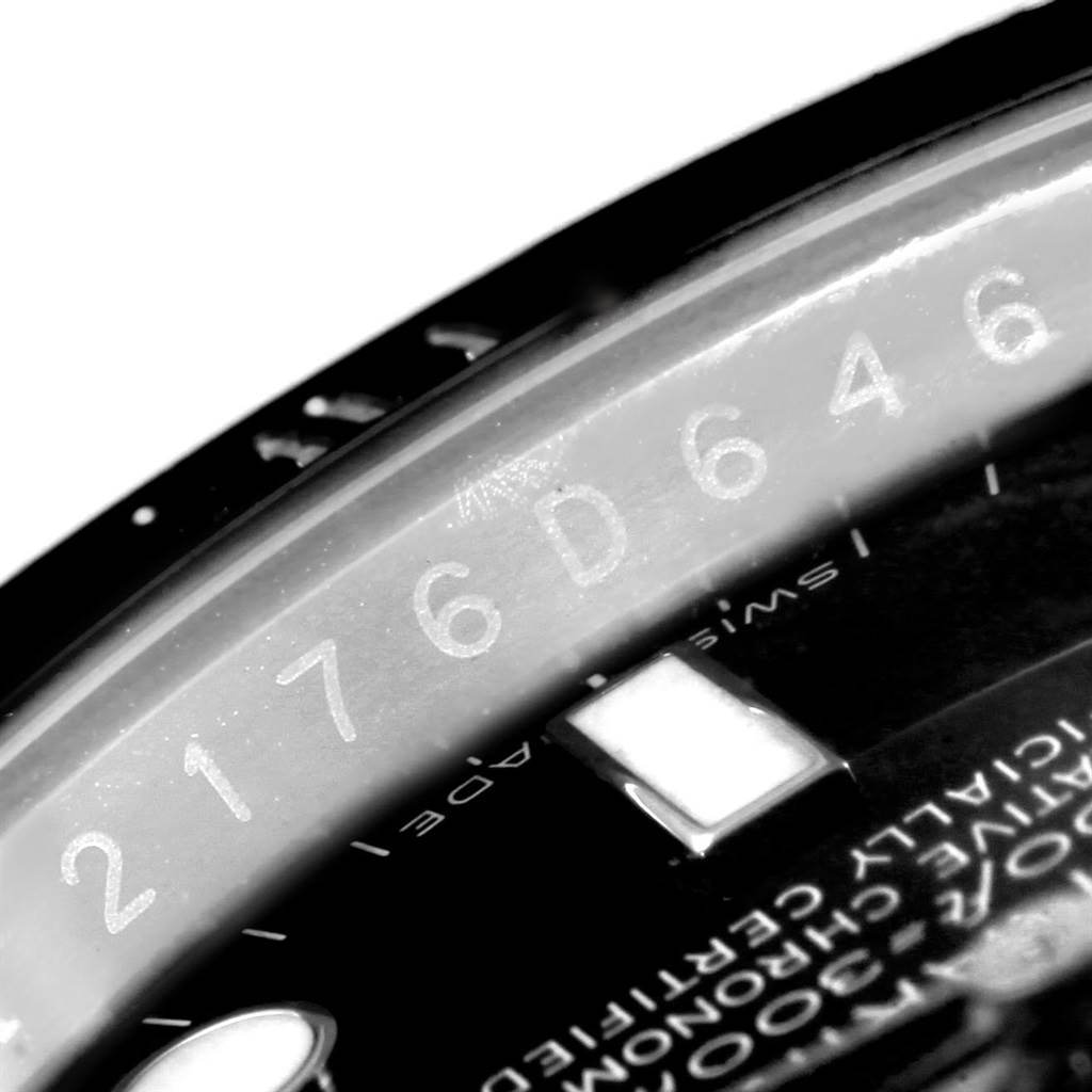 This close-up image of a Rolex Submariner 116610 Men's Stainless Steel Black Dial 116610 Men's Stainless Steel Black Dial watch shows part of the dial and the rehaut with the serial number engraved.