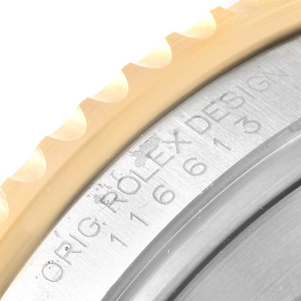 This image shows a close-up of the engraved inner bezel and outer edge of a Rolex Submariner 116613 Men's Steel and Gold (two tone) Black Dial 116613 Men's Steel and Gold (two tone) Black Dial watch.
