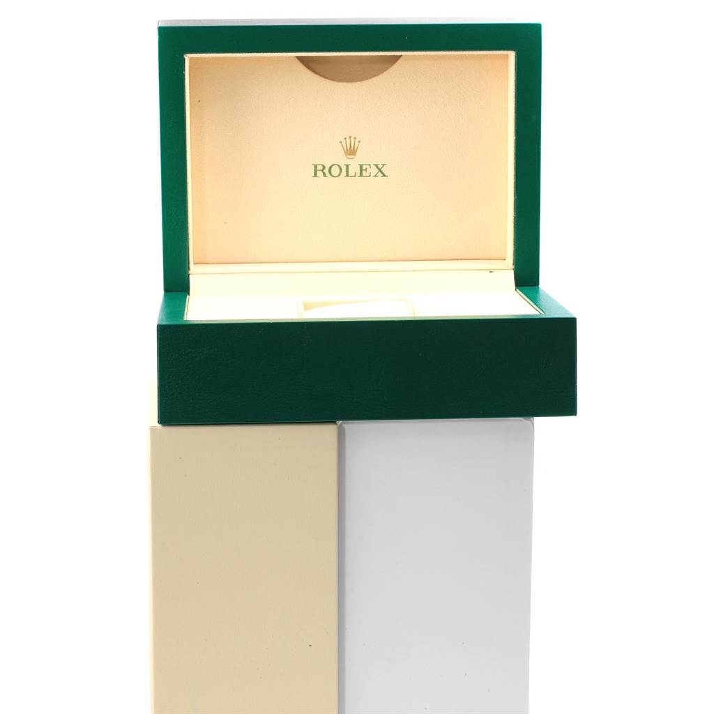 The image shows an open green and beige Rolex box for the Submariner model, displaying the inside with the brand's logo.