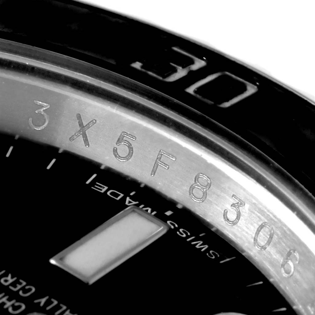This is a close-up view of a Rolex Submariner 114060 Men's Stainless Steel Black Dial 114060 Men's Stainless Steel Black Dial watch showing the rehaut with engraved serial number and part of the dial.