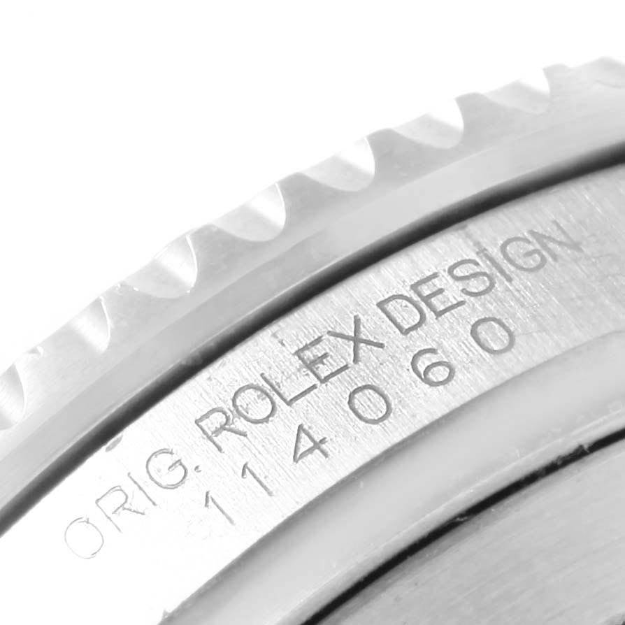 The image shows a close-up of the bezel and engraved serial number of a Rolex Submariner 114060 Men's Stainless Steel Black Dial 114060 Men's Stainless Steel Black Dial watch.