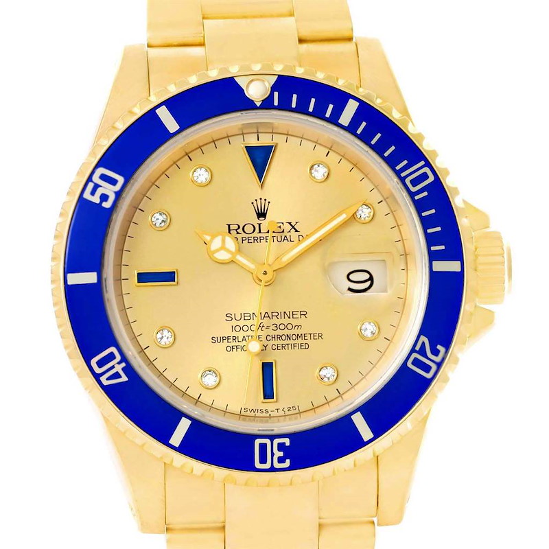 The image shows a close-up of a Rolex Submariner 16618 Men's Yellow Gold Champagne Dial 16618 Men's Yellow Gold Champagne Dial watch face and part of the bracelet, highlighting the gold and blue color scheme.