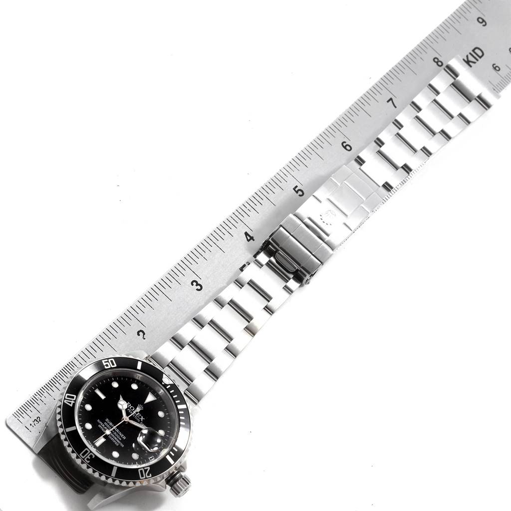 The image shows a top-down view of a Rolex Submariner 16610 Men's Stainless Steel Silver Dial 16610 Men's Stainless Steel Silver Dial watch with a ruler measuring the length of its metal bracelet.