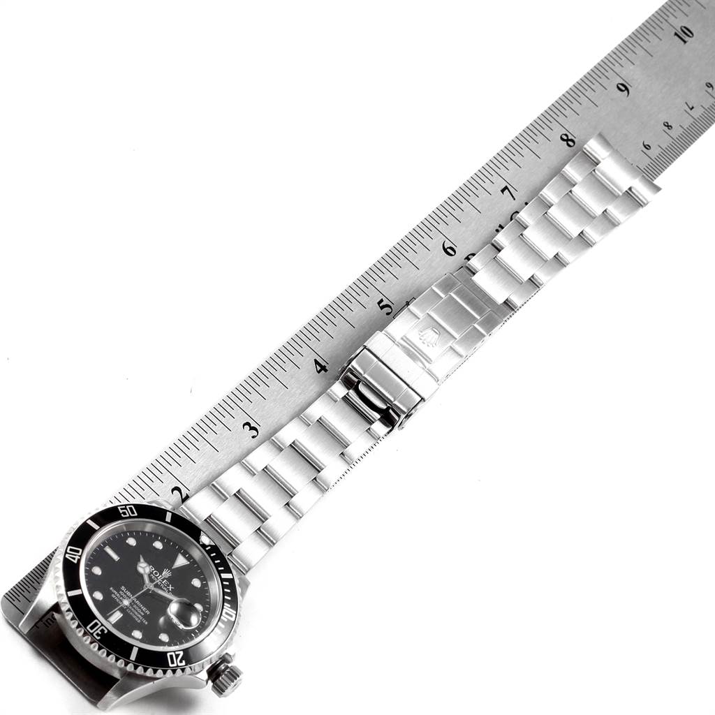 The image shows a top-down view of a Rolex Submariner 16610 Men's Stainless Steel Black Dial 16610 Men's Stainless Steel Black Dial watch, highlighting the face, bezel, and metal bracelet with a ruler for scale.