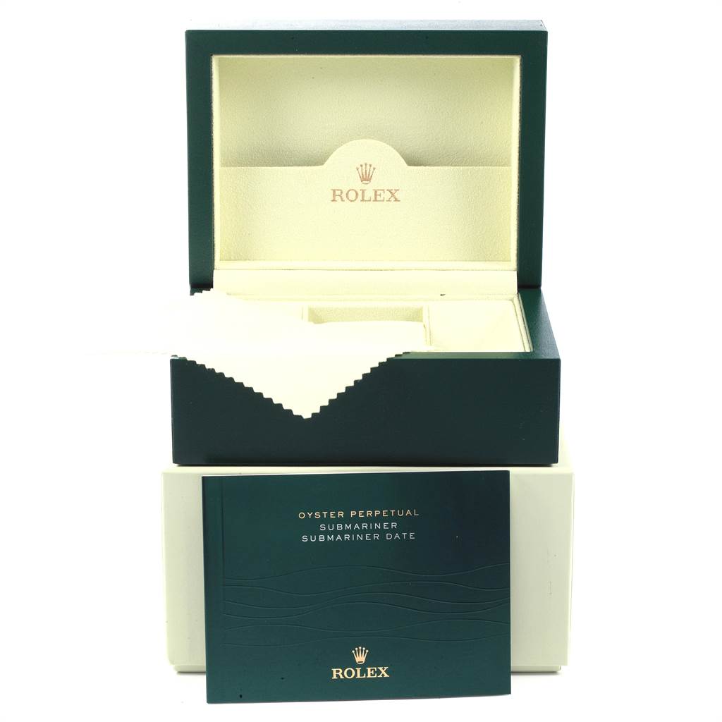 This image shows an open Rolex Submariner 16610 Men's Stainless Steel Black Dial 16610 Men's Stainless Steel Black Dial watch box with its accompanying booklet in front.