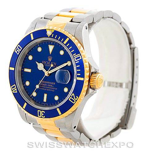 The image shows a Rolex Submariner 16613 Men's Steel and Gold (two tone) Blue Dial 16613 Men's Steel and Gold (two tone) Blue Dial watch at a three-quarter angle, highlighting its blue dial, two-tone band, and bezel.