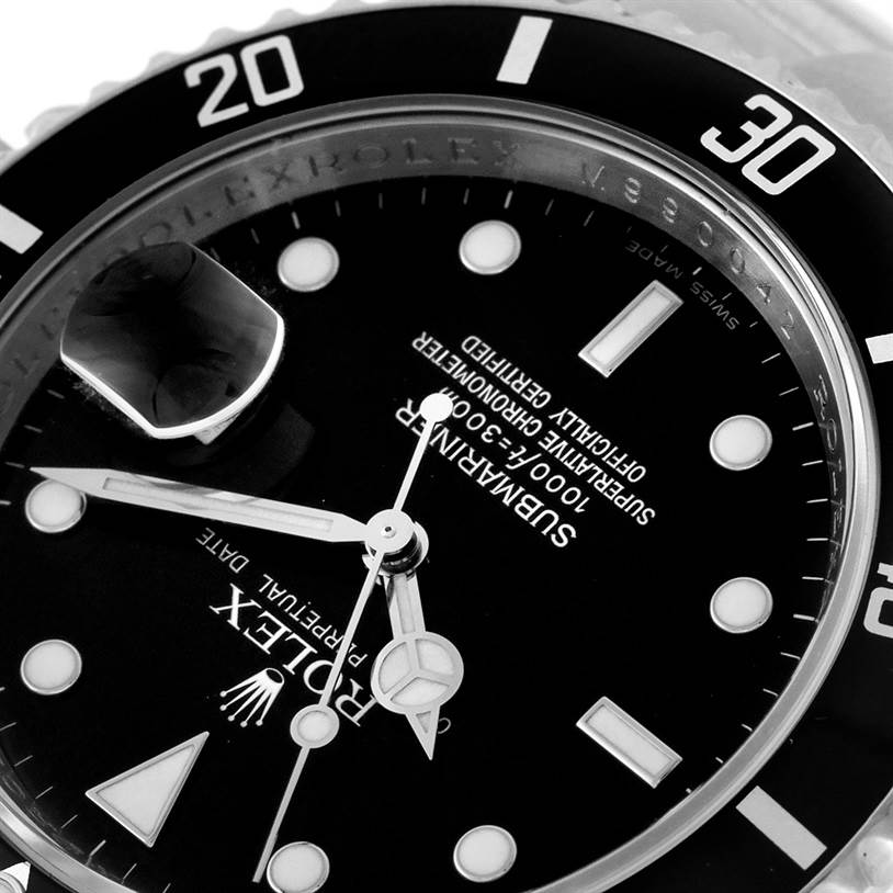 The image shows a close-up of the Rolex Submariner 16610 Men's Stainless Steel Black Dial 16610 Men's Stainless Steel Black Dial's dial and bezel at an angle, highlighting the date magnifier and luminescent markers.