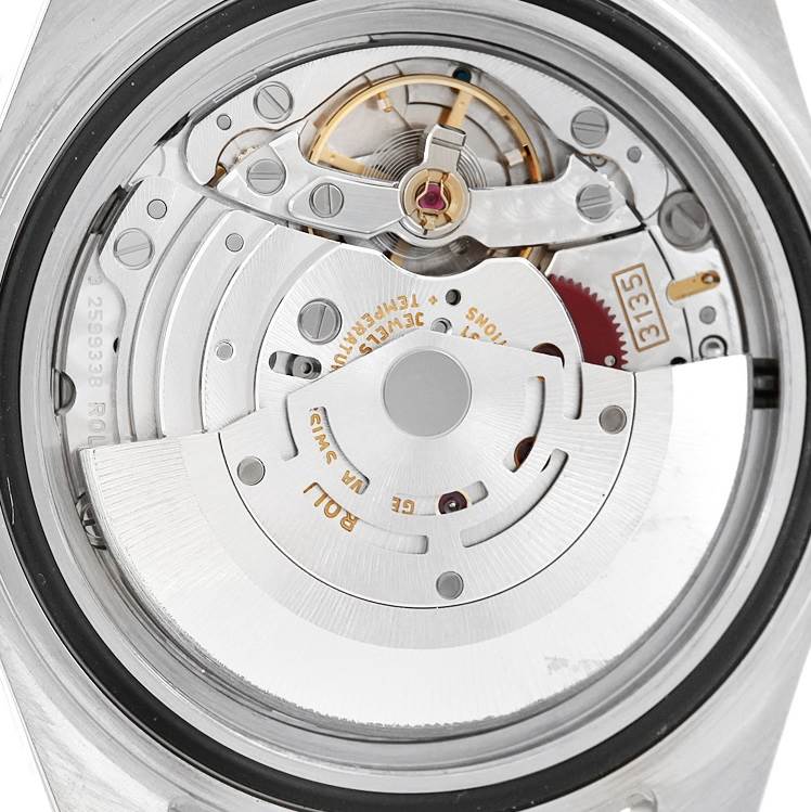 This image shows the movement mechanism of a Rolex Submariner 16610 Men's Stainless Steel Black Dial 16610 Men's Stainless Steel Black Dial watch from the back angle, detailing the oscillating weight and gears.