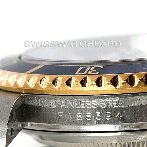 This image shows a close-up of the side view of a Rolex Submariner 16613 Men's Steel and Gold (two tone) Blue Dial 16613 Men's Steel and Gold (two tone) Blue Dial, focusing on the bezel and part of the stainless steel case with the serial number.