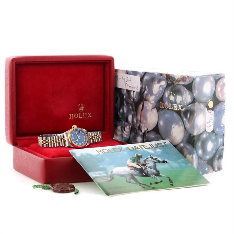 The Rolex Datejust 69173 Women's Stainless Steel Blue Dial 69173 Women's Stainless Steel Blue Dial watch is shown in a red box with its booklet, outer case, and accessories at a straight-on angle.