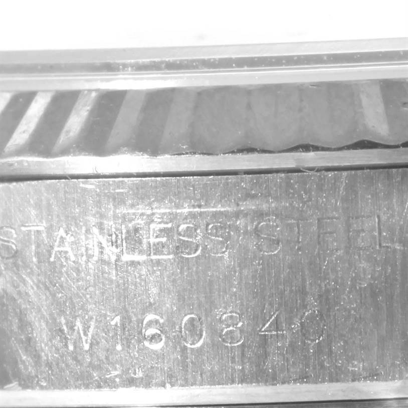 The image shows a close-up of the stainless steel case and fluted bezel with the serial number of a Rolex Datejust 69174 Women's Stainless Steel Black Dial 69174 Women's Stainless Steel Black Dial watch.