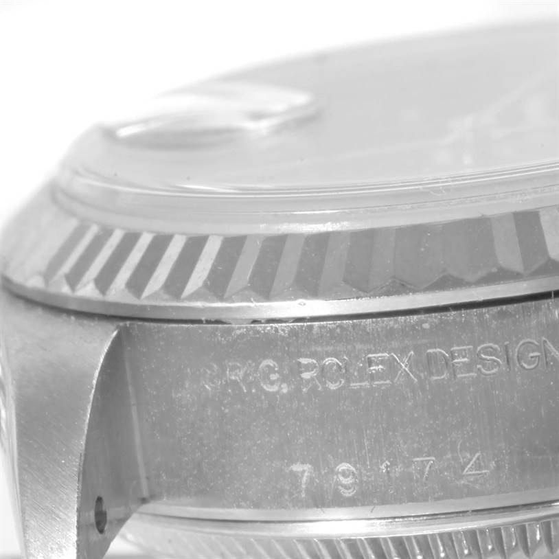 The image shows a close-up of the side of the case and the fluted bezel of a Rolex Datejust 79174 Women's Stainless Steel Blue Dial 79174 Women's Stainless Steel Blue Dial watch.