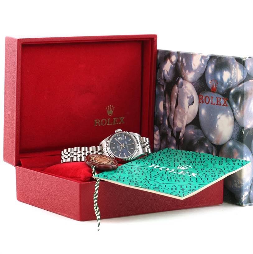 The Rolex Datejust 79174 Women's Stainless Steel Blue Dial 79174 Women's Stainless Steel Blue Dial watch is shown in an open red box, displaying the face, bracelet, and accompanying documents.