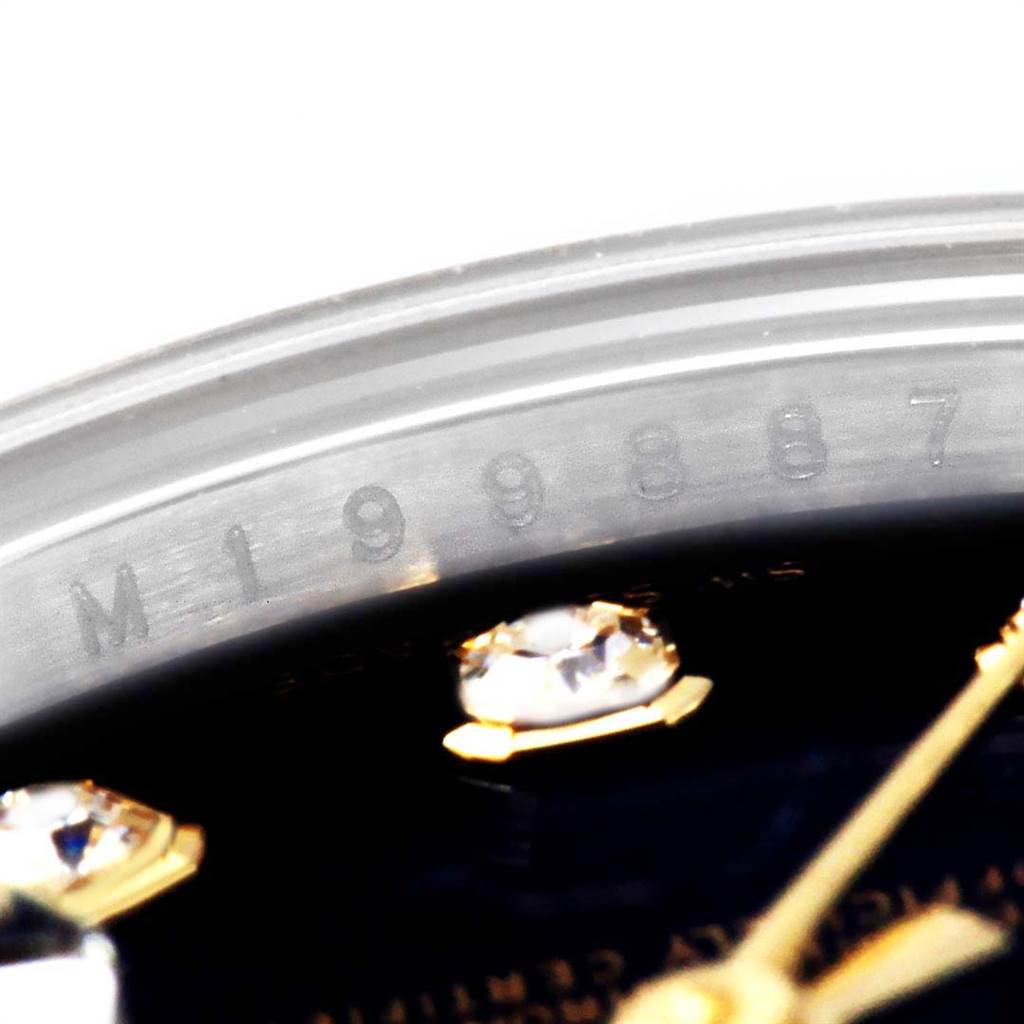 This close-up image of a Rolex Datejust 179173 Women's Steel and Gold (two tone) Black Dial 179173 Women's Steel and Gold (two tone) Black Dial watch shows the serial number engraved on the inner bezel and parts of the dial.