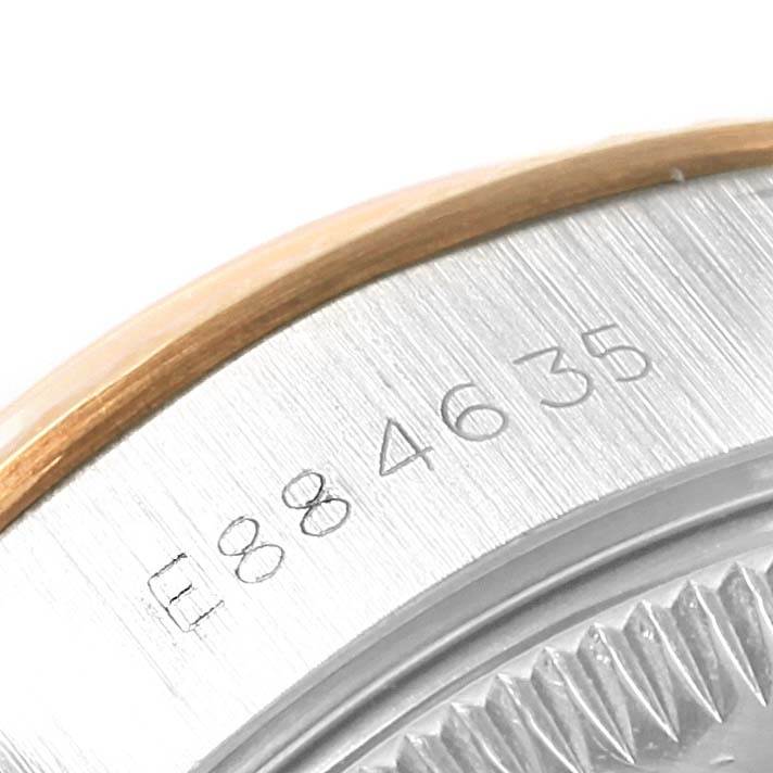 This close-up image of the Rolex Datejust 69173 Women's Stainless Steel Champagne Dial 69173 Women's Stainless Steel Champagne Dial watch shows part of the case back with engraved serial numbers.