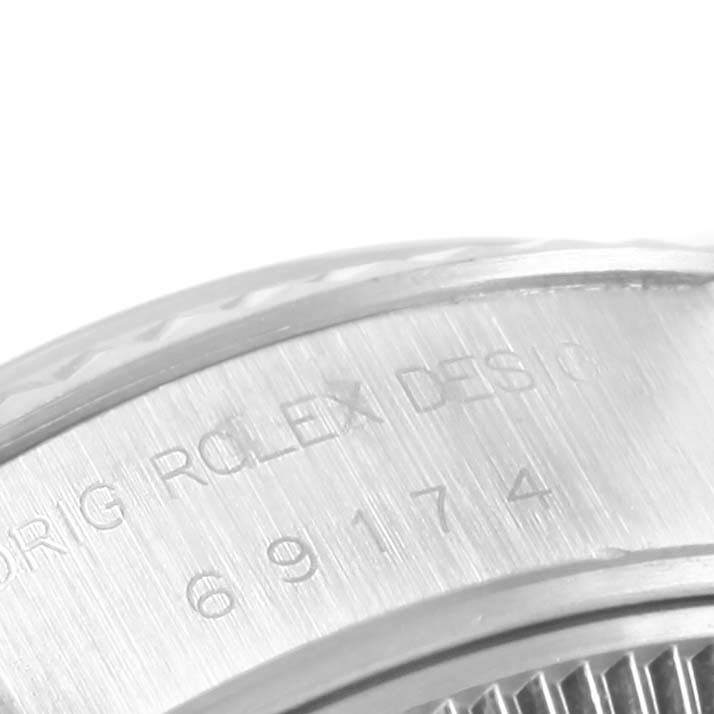 The image shows a close-up of the side engraving on the casing of a Rolex Datejust 69174 Women's Stainless Steel Blue Dial 69174 Women's Stainless Steel Blue Dial watch.