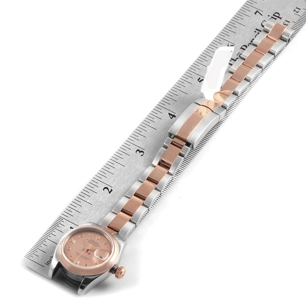 The Rolex Datejust 179161 Women's Steel and Gold (two tone) Pink Dial 179161 Women's Steel and Gold (two tone) Pink Dial watch is shown flat, displaying its face, bracelet, and clasp alongside a measuring ruler.