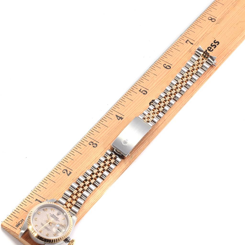 The image shows a top-down view of a Rolex Datejust 69173 Women's Stainless Steel Beige Dial 69173 Women's Stainless Steel Beige Dial watch laid next to a ruler, prominently displaying its face and bracelet.