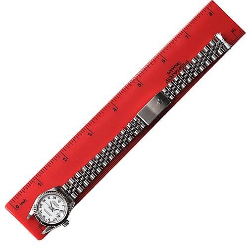 The image shows a side view of a Rolex Datejust 79174 Women's Stainless Steel White Dial 79174 Women's Stainless Steel White Dial model watch, highlighting its face, bracelet, and clasp, next to a red ruler.