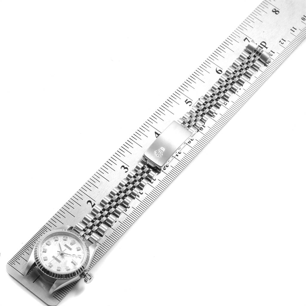 The image shows the Rolex Datejust 79174 Women's Stainless Steel Silver Dial 79174 Women's Stainless Steel Silver Dial watch laying flat on a ruler, highlighting the face, bracelet, and clasp.