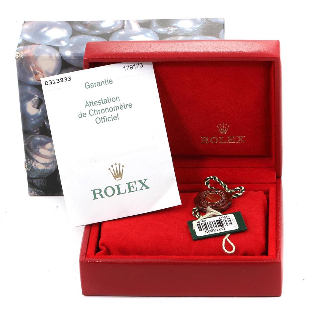 The image shows a red Rolex Datejust 179173 Women's Steel and Gold (two tone) Mother of Pearl Dial 179173 Women's Steel and Gold (two tone) Mother of Pearl Dial watch box with a guarantee certificate and a Rolex tag inside.
