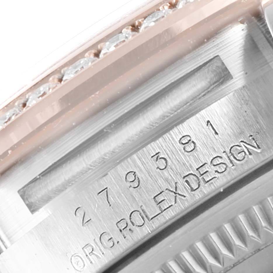 A close-up of the Rolex Datejust 279381 Women's Steel and Gold (two tone) Brown Dial 279381 Women's Steel and Gold (two tone) Brown Dial model shows the serial number engraving and part of the diamond-studded bezel.