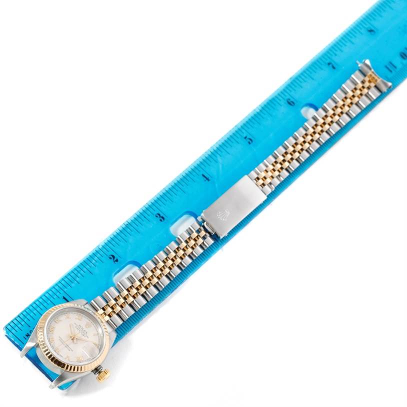 The image shows a Rolex Datejust 69173 Women's Stainless Steel Beige Dial 69173 Women's Stainless Steel Beige Dial watch placed next to a ruler, displaying its face, bezel, and two-tone bracelet.