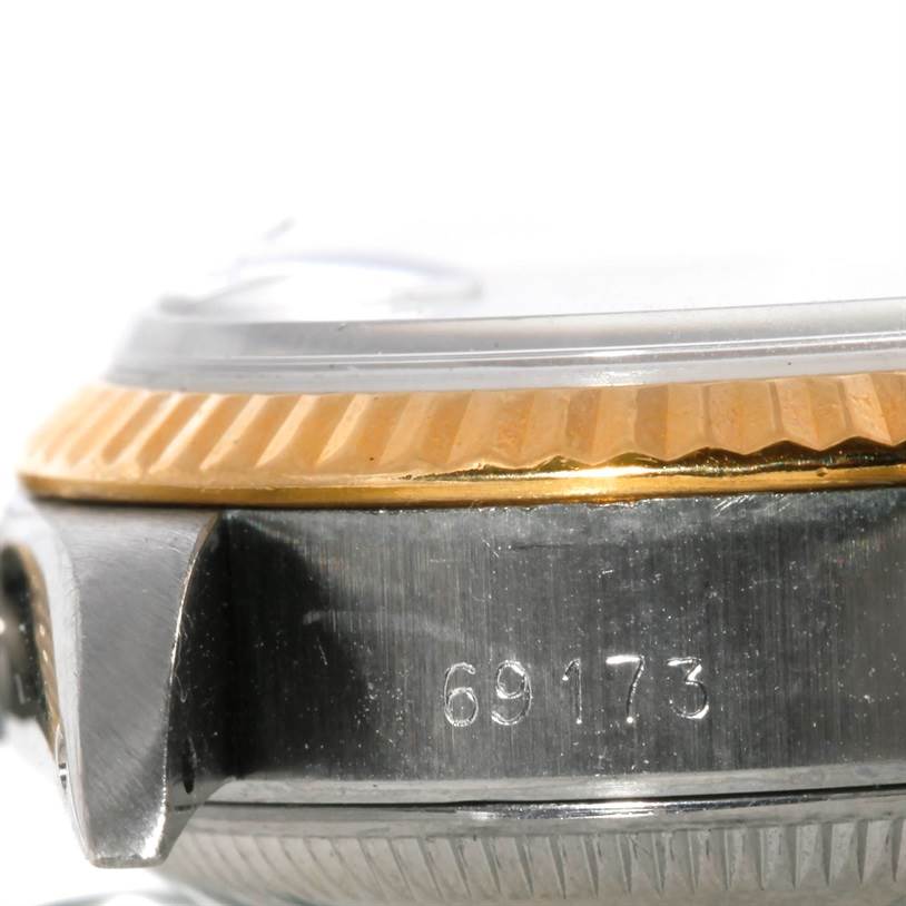 This is a close-up of the side of a Rolex Datejust 69173 Women's Stainless Steel Beige Dial 69173 Women's Stainless Steel Beige Dial watch, showcasing the bezel and part of the case with a partial serial number.