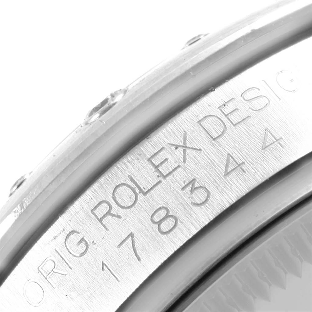 This image shows a close-up of the engraved bezel and side of a Rolex Mid-Size 178344 Women's Stainless Steel Purple Dial 178344 Women's Stainless Steel Purple Dial watch, model 178344.