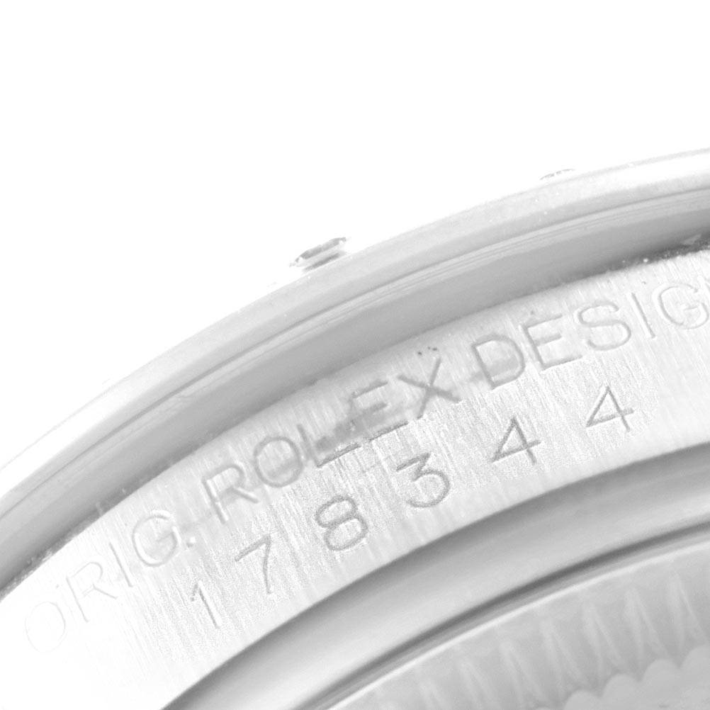 This close-up image of a Rolex Mid-Size 178344 Women's Stainless Steel Brown Dial 178344 Women's Stainless Steel Brown Dial model shows part of the watch case with engraved text and serial numbers.