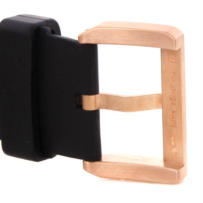 This image shows a close-up of a Santos by Cartier watch buckle in gold and black.