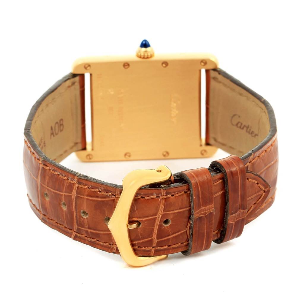 The image shows the back of a Cartier Tank Louis W1529756 Men's Yellow Gold Silver Dial W1529756 Men's Yellow Gold Silver Dial watch, featuring its leather strap and gold buckle.